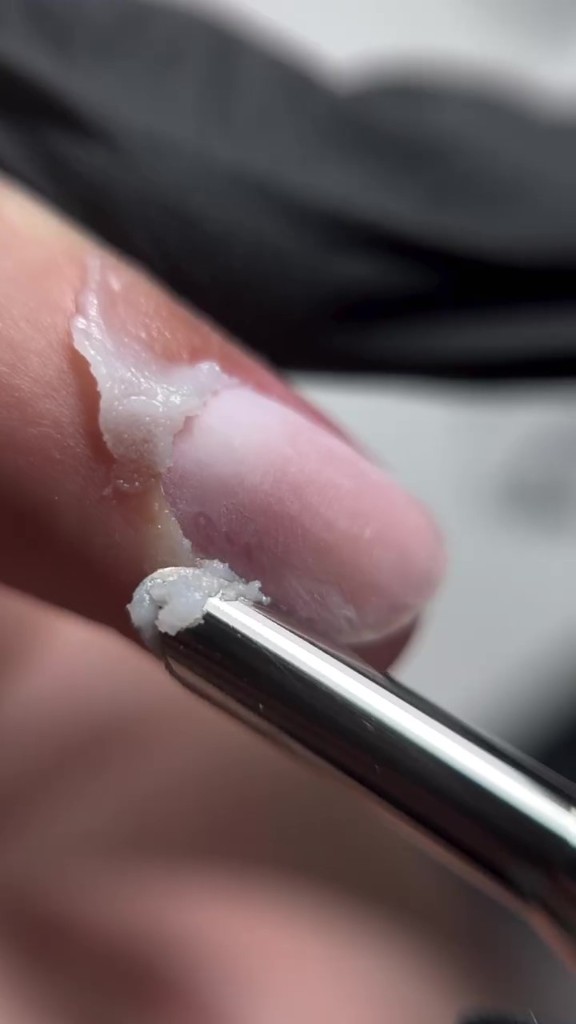 Aplicación de Black Milk Wax sobre cutícula en manicura profesional Colombia